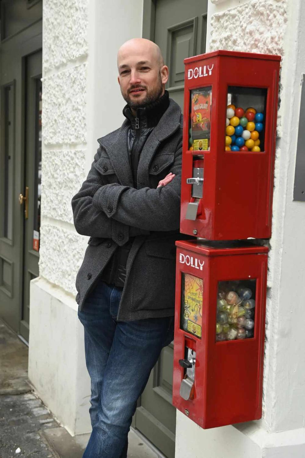 Geschäftsführer Hannes Viehhauser neben zwei übereinander montierten roten Kaugummiautomaten
