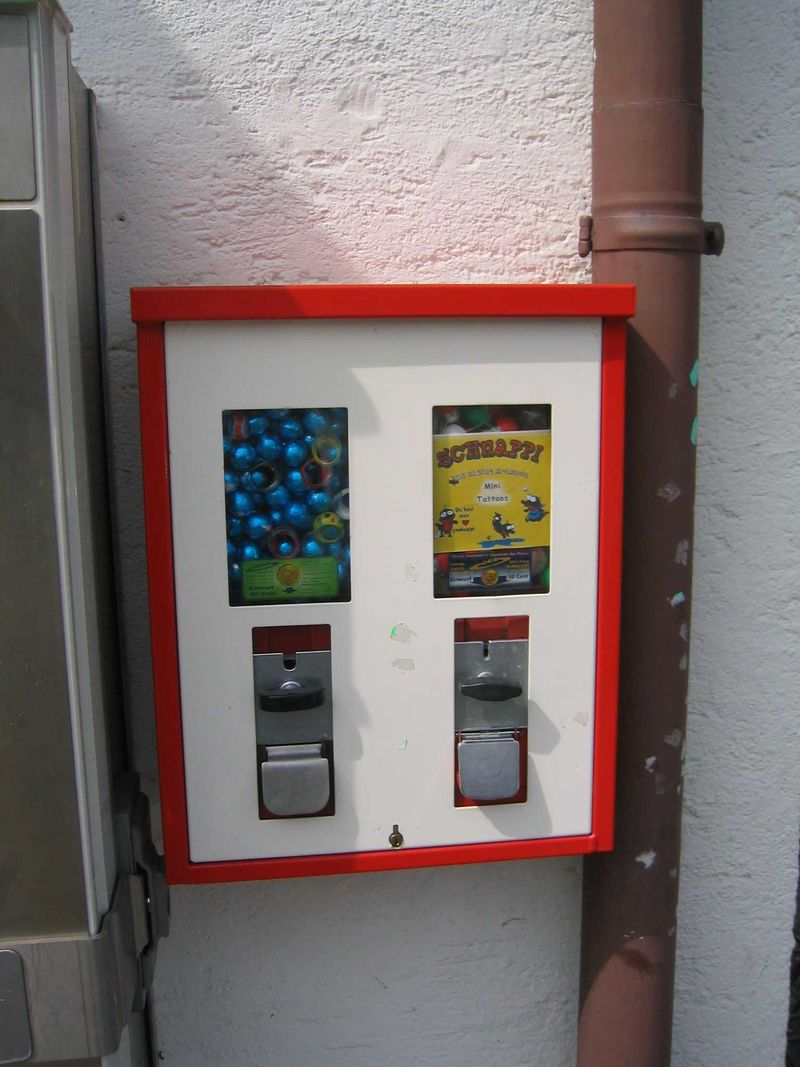 Rot-weißer Automat mit zwei Füllungen an einer Hausecke
