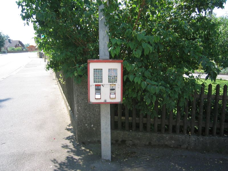 Wandautomat an einem Pfosten neben einem Gartenzaun
