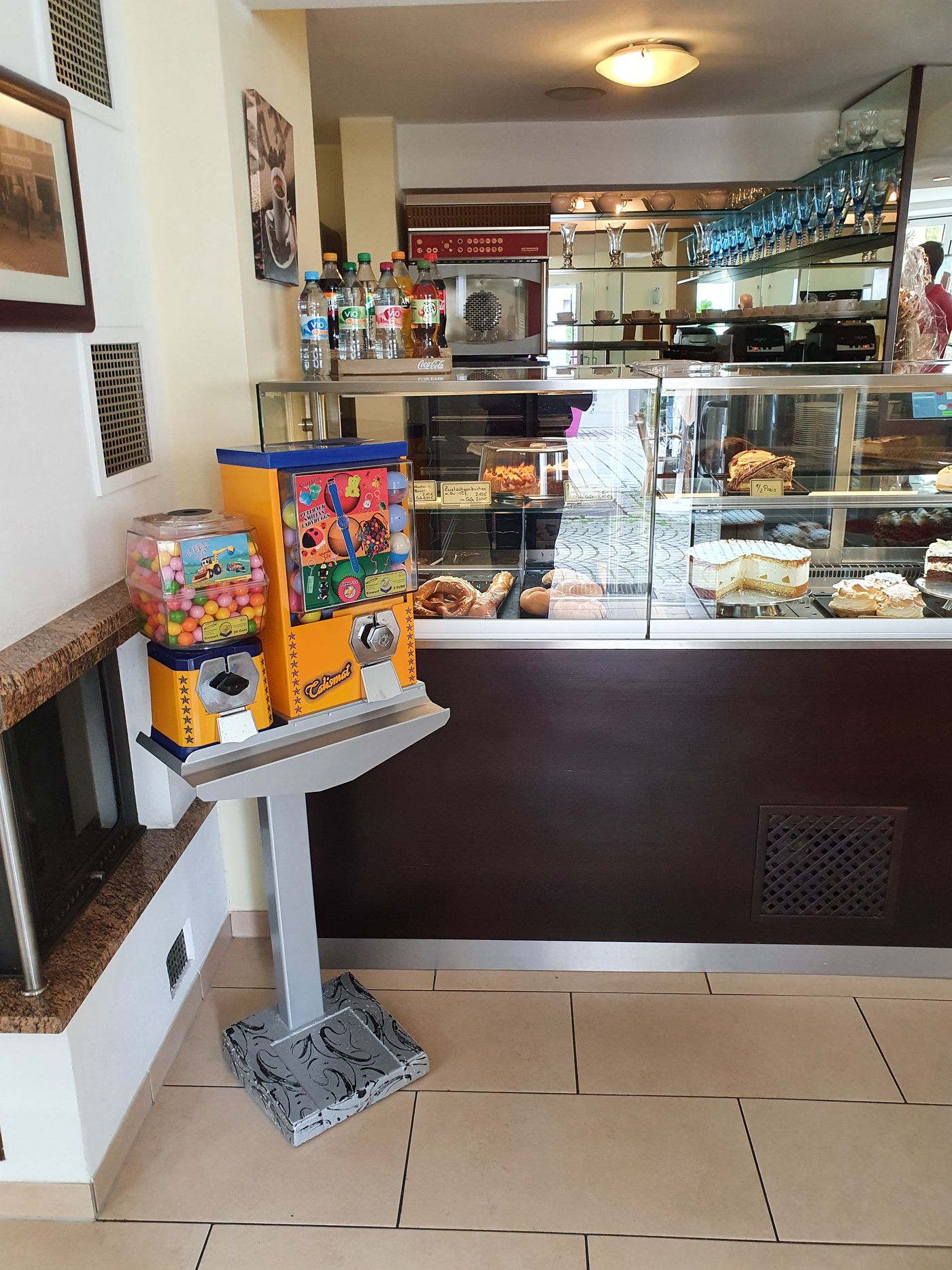 Gelber Talismat und Kaugummiautomat auf einem Ständer in einem Café