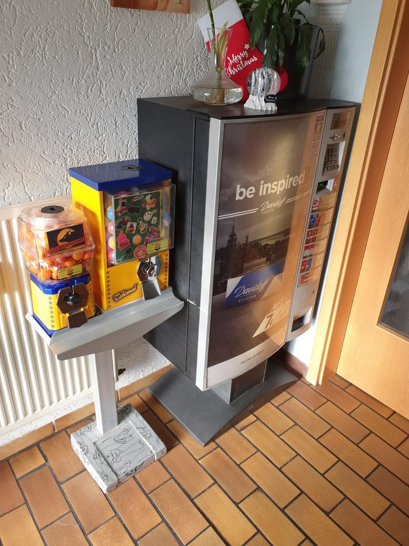 Talismat und Kaugummiautomat auf einem Ständer in einem Eingangsbereich